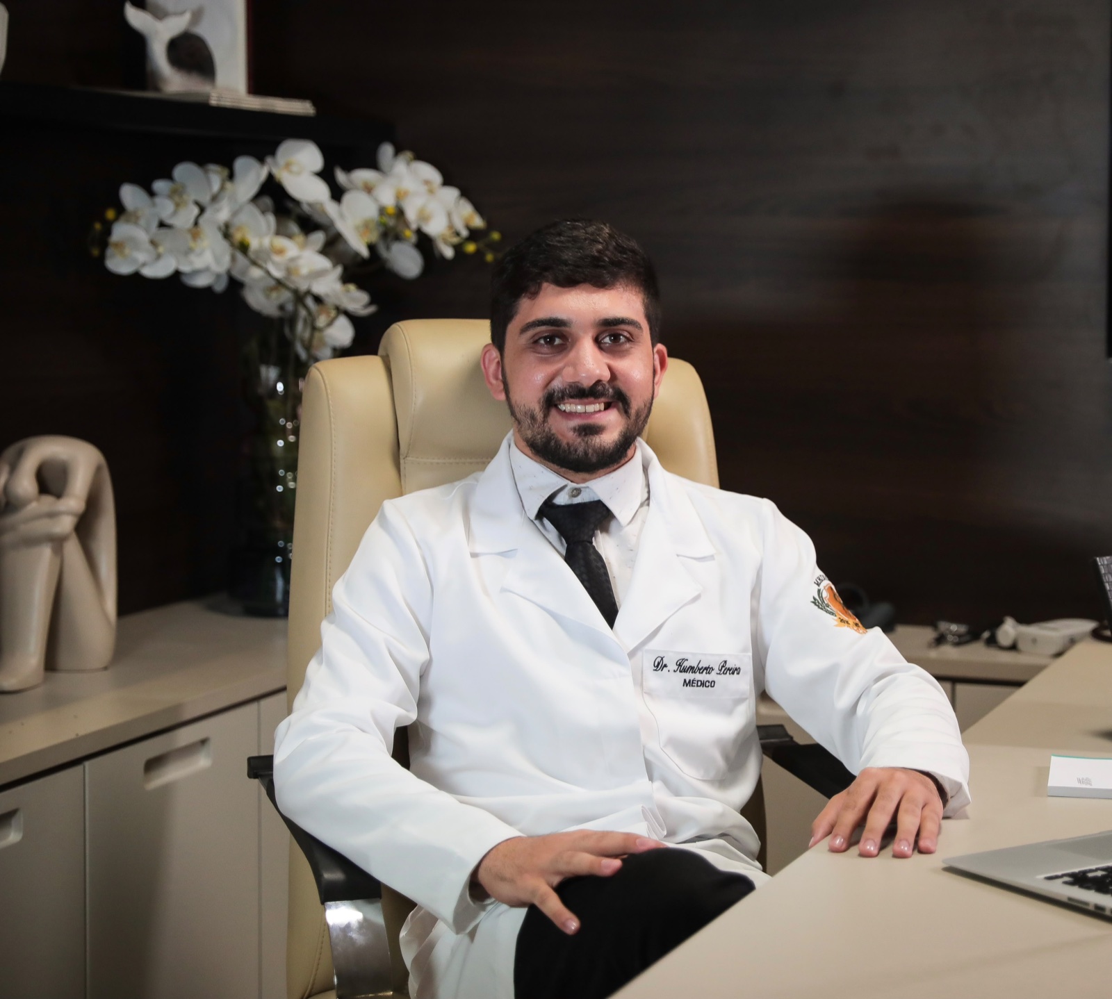 Dr. Humberto Pereira Roque, médico, sentado em seu consultório